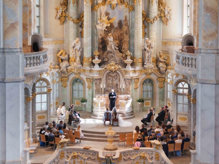 Brautpaar in Frauenkirche Dresden Ein prächtiger Kirchenraum mit einer sermoniellen Veranstaltung und versammeltem Publikum.